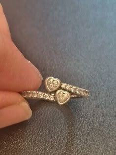 Elevate your jewellery collection with this genuine PANDORA ring, featuring a stunning cross-over design with double heart motifs. Crafted from high-quality 925 sterling silver, this ring boasts a brilliant heart-shaped cubic zirconia stone as its main attraction. The ring size, K or 50, is perfect for those who prefer a smaller fit. Ideal for any occasion or as a gift to your loved one, this ring will surely add a touch of elegance to your outfit. Rings Pandora, Double Heart Ring, Pandora Ring, Pandora Rings, Rings Jewelry Fashion, Main Attraction, Over Size, Double Heart, Jewellery Collection