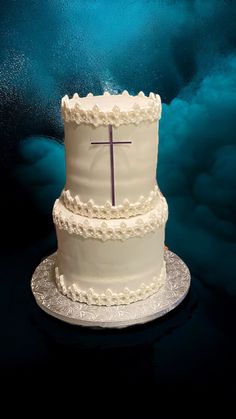 a three tiered cake with a cross on top