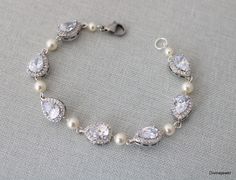 This elegant bracelet is made with cubic zirconia teardrops and hand linked Austrian pearls in your choice of color.  It has the right amount of sparkle to complement your wedding theme or special occasion event.   It measures approximately 7" long and pearls measure 5mm.  It is finished off with a lobster claw clasp and 1 1/2" extender chain for additional length.  Available in three finishes, silver, gold, and rose gold.  Austrian pearls are available in different shades.  Please choose yours Bracelet Pearl, Bracelet Wedding, Pearl Bridal, Wedding Jewelry Bracelets, Rhinestone Wedding, Elegant Bracelet, Bridal Bracelet, Rhinestone Bracelet, Bridal Pearls