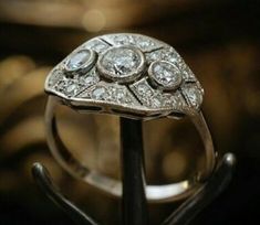 an antique diamond ring is displayed on a stand