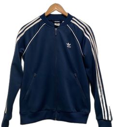 Classic Long Sleeve Track Jacket For Spring, Blue Outerwear With Ribbed Cuffs For Fall, Navy Long Sleeve Track Jacket For Fall, Casual Blue Adidas Outerwear, Navy Track Jacket For Spring Streetwear, Navy Adidas Track Jacket For Streetwear, Adidas Navy Track Jacket For Streetwear, Blue Adidas Track Jacket For Spring, Adidas Blue Track Jacket For Spring