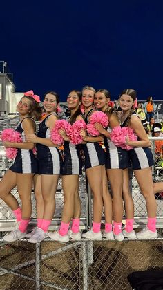 a group of cheerleaders standing next to each other