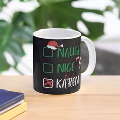 a black and white coffee mug sitting on top of a table next to a book