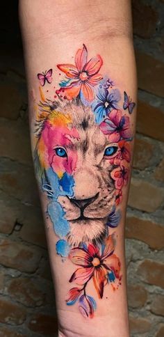 a colorful tattoo with a lion and flowers on the leg, which is painted in watercolor