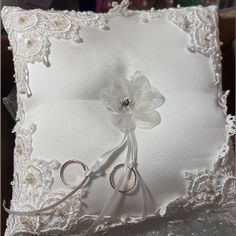 the ring bearer pillow is white and has flowers on it, along with two pairs of scissors