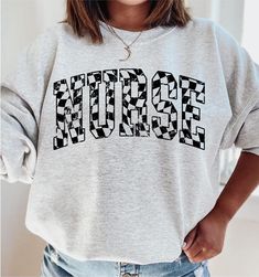 Retro Checkered Nurse Sweatshirt, RN Sweatshirt Nurse Registered Nurse Sweater, Nursing Crewneck, RN Graduation Gift for New Nurse, Er Icu How to Order 1* View all color and size charts before you place your order. 2* Select your shirt "SIZE" and "COLOR". 3* Click add to cart.  If you are ordering more than 1 item, you need to repeat this process for each item you wish to order. Product Information Gildan Hoodie- Sweatshirt 8 oz.(US) 13.3 oz.(CA), 50/50 preshrunk cotton/polyester Heather Sport colors: 60/40 polyester/cotton Air jet yarn = softer feel and reduced pilling Double needle stitching at shoulder, armhole, neck, waistband and cuffs 1 x 1 rib with spandex Quarter-turned to eliminate center crease Safety Green: Compliant with ANSI / ISEA 107 Tearaway label Washing Care Instructors U Nursing Student Shirts Ideas, Er Nurse Shirt, Nursing Crewneck, Nursing School Outfit, Nursing Student Shirts, Nurse Sweater, New Nurse, Er Nurse, Nurse Sweatshirt