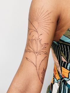 a woman with a flower tattoo on her arm