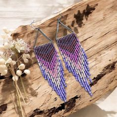 Add a vibrant touch of summer to your wardrobe with these Beadwork Summer Purple Ombre Hoop Fringe Earrings. Handcrafted with precision, these earrings feature a stunning purple ombre design that transitions beautifully across the fringe. The triangular statement shape and delicate beadwork make them perfect for anyone looking to embrace a boho chic style with a fresh spring vibe. These earrings are lightweight and eye-catching, making them ideal for casual wear or special occasions. Whether you Ombre Earrings, Ombre Design, Boho Chic Style, Purple Ombre, Spring Vibes, Style Spring, Fringe Earrings, Boho Chic Fashion, Statement Jewelry