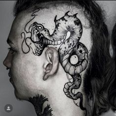 a man with tattoos on his face and neck is looking down at the side of his head