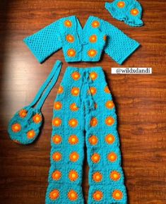 a crocheted blue outfit with orange dots on it