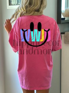 a woman wearing a pink shirt with a smiley face drawn on the back of it