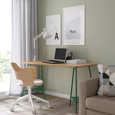 a laptop computer sitting on top of a wooden desk next to a chair in front of a window