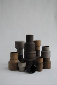 a stack of vases sitting on top of each other in front of a white background