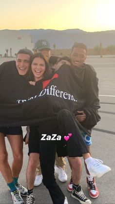 four people posing for a photo in front of an airport tarmac with their arms around each other