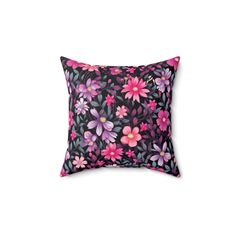 a black pillow with pink and purple flowers on it