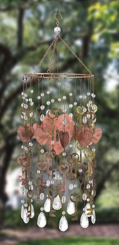 a wind chime hanging from a tree with lots of keys and hearts on it