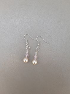 Silver drop-length earrings featuring cream pearl beads, pink transparent diamond-shaped beads and clear seed beads. These pretty earrings would look beautiful on a bride along with the matching bracelet.  Drop length measurement is the whole length including the ear wire. Cream Dangle Jewelry For Wedding, Pink Beaded Drop Earrings For Wedding, Elegant Pink Dangling Beads Earrings, Elegant Pink Crystal Earrings With Round Beads, Elegant Pink Teardrop Beaded Earrings, Pearl Earrings With Dangling Round Beads For Wedding, Pearl Drop Beaded Earrings For Wedding, Elegant Pink Pearl Drop Beaded Earrings, Wedding Pearl Drop Beaded Earrings With Round Beads