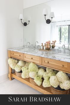 a bathroom with double sinks and marble counter tops