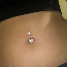 a woman's stomach with three small diamond studs attached to it, and the bottom part of her belly