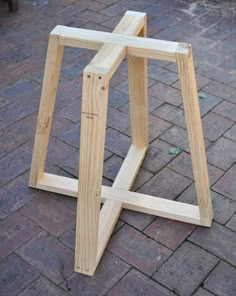 a wooden stool sitting on top of a brick floor