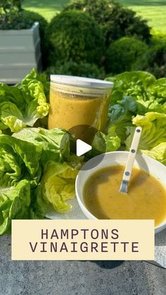 a bowl of soup sitting on top of a table next to some lettuce