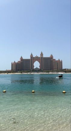 a large building sitting on top of a beach next to the ocean in front of it