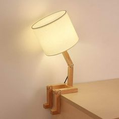 a lamp that is on top of a wooden table next to a wall mounted shelf