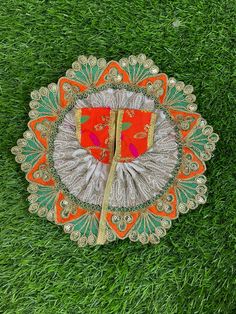 an orange and green doily on some grass