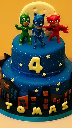 the birthday cake is decorated with three little hero cats on top and numbers 4 to 5