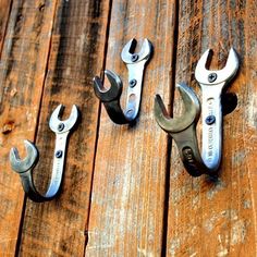 four wrenches are sitting on top of a wooden table