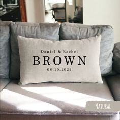 a personalized pillow on a couch with the names of two people in black and white