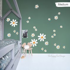 a child's bedroom with green walls and white daisies on the bedding