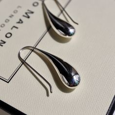 The silver liquid metal effect that gives them the appearance of a fresh raindrop is a unique and elegant that is sure to catch the eye. The contemporary design of the earrings with a teardrop shape and fixed hook drop setting makes them easy and fuss-free to wear, which is always a plus. The polished finish adds to their sleek and modern look, while the silver liquid metal effect gives them an organic and natural feel. these Sterling Silver liquid Drop Earrings are a beautiful and sophisticated Metal Drop Jewelry With Shiny Finish, Modern Long Drop Teardrop Earrings Gift, Metal Teardrop Jewelry With Shiny Finish, Modern Teardrop Sterling Silver Earrings, Silver Drop Jewelry With Shiny Finish, Metal Jewelry With Shiny Teardrop Finish, Teardrop Metal Jewelry With Shiny Finish, Modern Long Drop Earrings With Matching Set, Modern Polished Teardrop Earrings