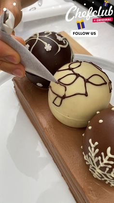 a person cutting into three chocolate covered desserts