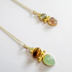 Introducing our Luminara Duo, an exquisite piece handcrafted from sterling silver and plated in 14k gold. This elegant necklace features two stunning gemstones, one delicately placed above the other, creating a timeless silhouette. With an adjustable chain for a perfect fit and a waterproof design for lasting durability, this piece blends style and function effortlessly. Available in two sophisticated options: Green Aventurine - Tiger Eye, offering earthy tones and grounding energy. Pink Tourmal Gold Natural Gemstones In Sterling Silver, Fine Jewelry Gemstone Beads Gift, Spiritual Style Emerald Pendant Necklace, Yellow Gold Natural Stone Pendant Gemstones, Fusion Style May Birthstone Jewelry Gift, May Birthstone Fusion Style Gift Jewelry, Artisan Birthstone Pendant Necklace, Fusion Style Jewelry With May Birthstone For Gift, Yellow Gold Pendant Gemstones With Natural Stones