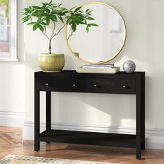 a black console table with a mirror and potted plant