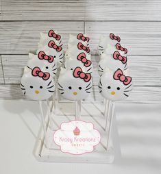 hello kitty cupcakes with pink bows on them are sitting in a display rack