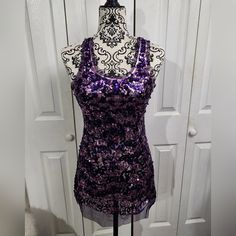 Junior's Size Large. This Stunning Wet Seal Tunic Tank Top Features A Purple Sequin Swirl Pattern That Catches The Light Beautifully, Making It Perfect For Parties Or Casual Wear. The Sleeveless Design With A Scoop Neck And Racerback Strap Type Adds A Touch Of Elegance To The Look. This Tunic Tank Top Is Made Of A Stretchy Polyester Material And Is Semi-Sheer, Making It Comfortable To Wear During Summer, Fall, And Spring. The Pullover Closure And Tie Knot Accent On The Straps In The Back Complet Fitted Purple Tank Top For Night Out, Fitted Racerback Tank Top For Party, Purple Tank Top For Party, Purple Tank Top For Parties, Tunic Tank Tops, Swirl Pattern, Tie Knots, Wet Seal, Summer Fall