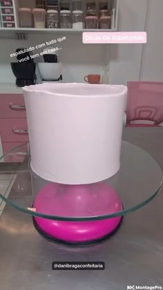 a pink and white vase sitting on top of a glass table