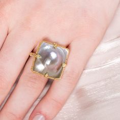 This natural Mabe Pearl is in the shape of a square. It seems to burst out of its golden frame, giving it a 3D quality. We highlighted the natural beauty of this one-of-a-kind gemstone by encasing it in a handmade, 18k gold bezel.Ready to ship in size 7. Please allow 1-2 weeks for any other size. Technical Details Metal: 18k yellow goldMabe Pearl: 18.42 cts.Ring face: 22 x 22mmBand width: 2mmHandmade in New YorkStyle # R-2467-MP Luxury Formal Pearl Ring With Cabochon, Mabe Pearl Rings, Luxury Classic Multi-stone Pearl Ring, Luxury Baroque Pearl Ring, Luxury Yellow Gold Pearl Ring With Cabochon, Mixed Metal Bracelets, Textile Necklace, Mabe Pearl, Bracelet Collection