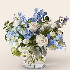 a glass vase filled with blue and white flowers