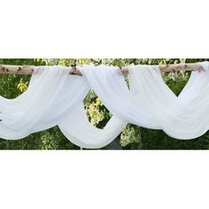 three white drapes hanging from a tree branch