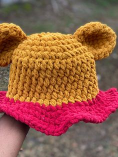 "Super cute Pooh inspired bucket hat! Perfect for your next trip to the parks! Fits 21\"-24\" circumference head. The yarn does stretch, so those with smaller heads will create a more oversized, loose look while those with bigger heads will find the hat snugger.  Also feel free to leave a note at checkout with measurements so I can adjust the size for an accurate fit!" Crochet Hats One Size For Outdoor, Playful Bucket Hat For Outdoor, One Size Fits Most, Knitted One Size Bucket Hat, One Size Fits Most Crochet Cap For Outdoor, Outdoor Crochet Bucket Hat, Outdoor Crochet Yarn Bucket Hat, Outdoor Yarn Crochet Bucket Hat, Playful Crochet Bucket Hat For Vacation, One Size Crochet Bucket Hat For Outdoor