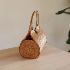 The Bali Rattan Wheel Handbag is the perfect accessory for any stylish woman. This beautiful, handmade rattan bag is made by skilled artisans in Bali, using natural materials to create a one-of-a-kind piece that is both fashionable and functional. The wheel design adds a unique touch to the classic rattan style, making it the perfect bag for everyday use or a night out. With its spacious interior and beautiful design, the Bali Rattan Wheel Handbag is sure to impress. Shop now and add a touch of Elegant Straw Bag With Round Handle In Natural Color, Handwoven Straw Shoulder Bag With Round Handle, Travel Straw Bag With Round Handle, Gold Shoulder Bag With Bamboo Handle, Eco-friendly Jute Bucket Bag With Bamboo Handle, Eco-friendly Natural Fiber Straw Bag With Round Handle, Straw Shoulder Bag With Round Bamboo Handle, Natural Color Jute Crochet Bag With Bamboo Handle, Elegant Natural Fiber Shoulder Bag In Natural Color