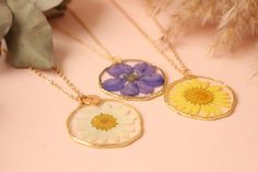 Fancy Pressed Flower Necklace Brand Fancy Material(s) Gold Plated Brass Size(s)/Dimensions(s) Circle Diameter: 36mm Made in Armenia Shipped from United States Unique necklace made from real flowers and clear resin.Unique and delicate gift idea for her.The petals have been carefully preserved to retain their color but please take care to keep this piece dry. NO LETTER CHARM INCLUDED. FOR LETTER CHARM, PLEASE CONTACT US. Delicate Floral Resin Jewelry, Floral Print Flower Necklaces For Gifts, Handmade Clear Flower Necklace, Pressed Flower Jewelry For Bridesmaid Gift, Gold Jewelry With Floral Print For Gift, Floral Print Flower-shaped Jewelry Gift, Floral Print Flower Shaped Jewelry Gift, Floral Print Flower Jewelry For Gifts, Round Floral Print Jewelry For Gift