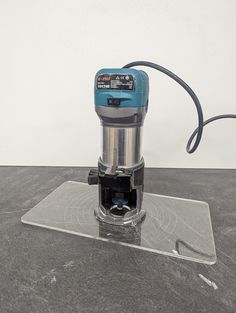 a blue and silver machine on top of a table with a cord attached to it