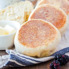 three english muffins with butter and berries on the side