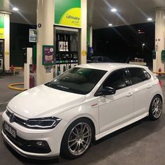 a white car parked in front of a gas station