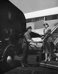 an old black and white photo of two people loading food onto a truck