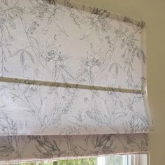 the blinds in this room are covered with floral fabric, and have been pulled back